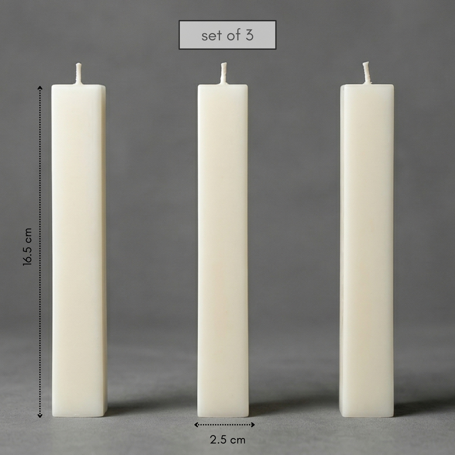 Three white candles of different heights on a gray background with measurements.