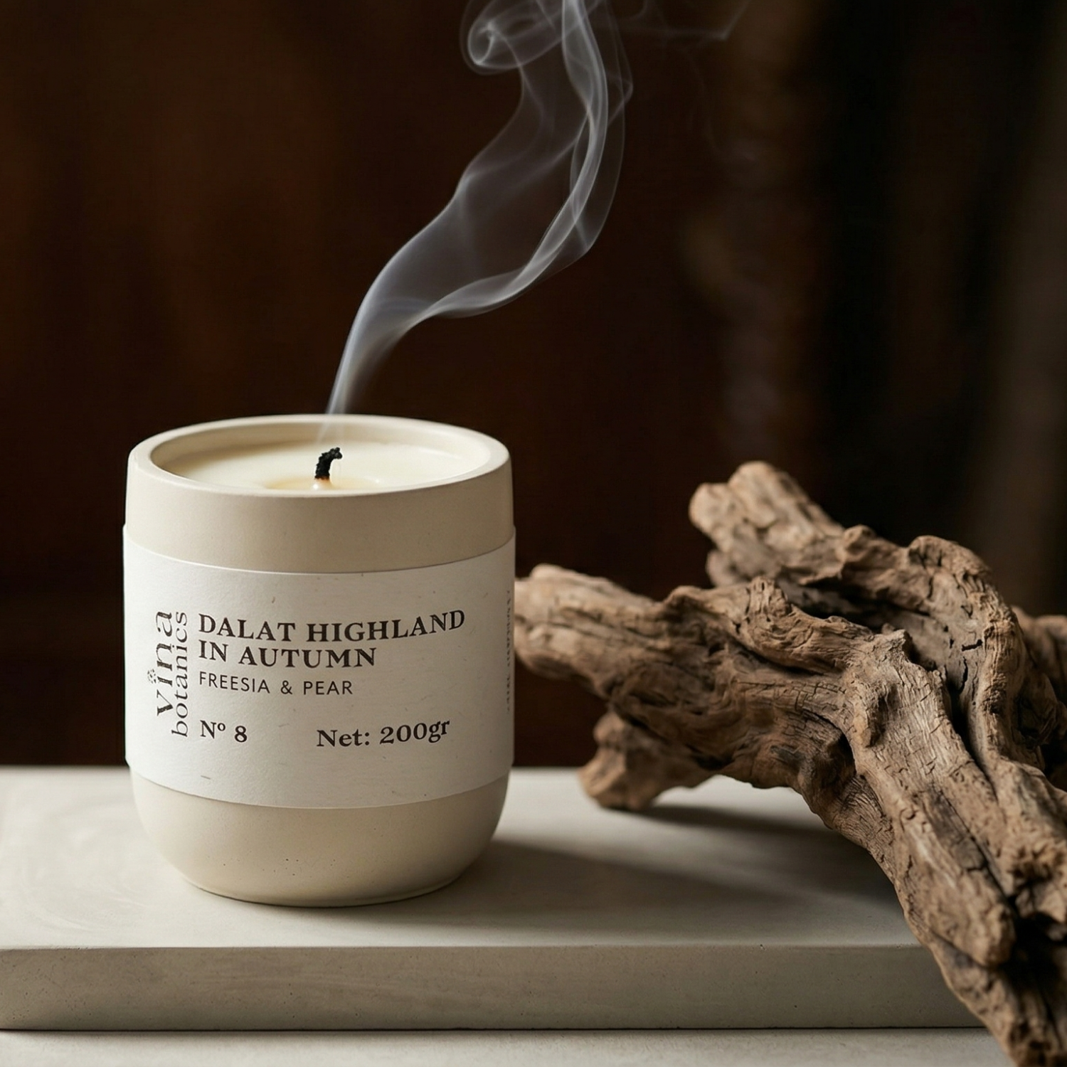 Candle labeled 'Dalat Highland in Autumn' with smoke rising, placed on a surface with a dark background.