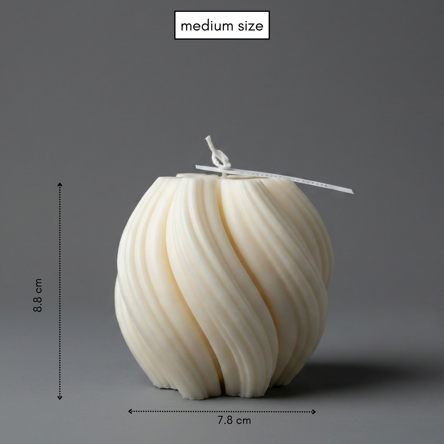 White spherical candle with dimensions on a gray background