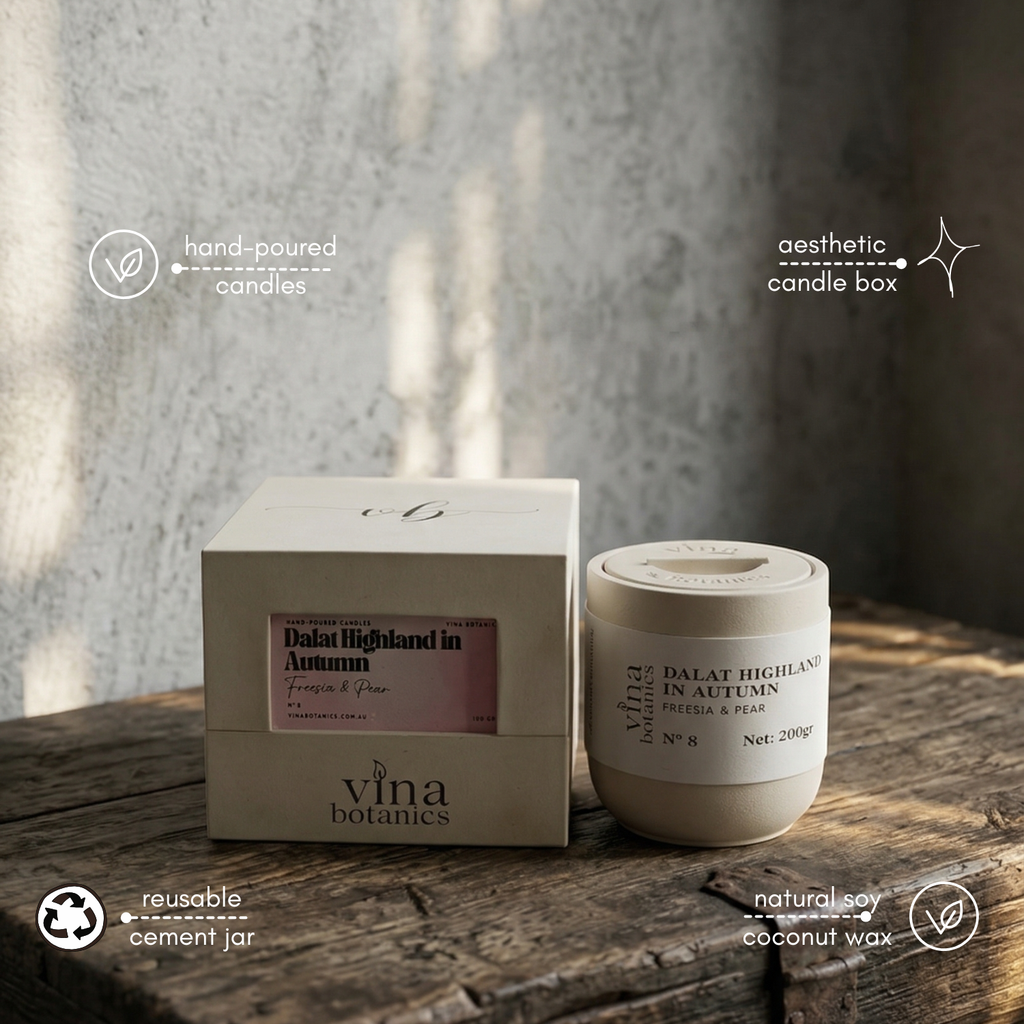 Vina Botanics candle and packaging on a wooden surface with a blurred background