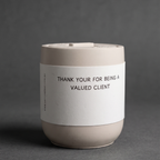 Ceramic cup with a label on a gray background