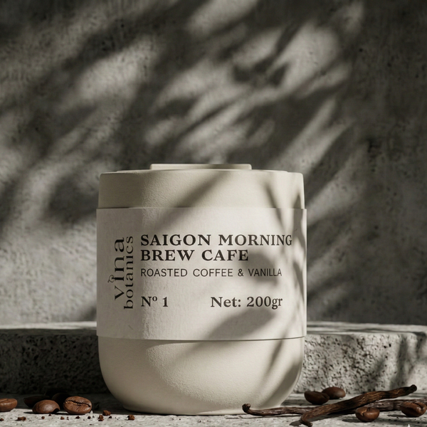 White container labeled 'Saigon Morning Brew Cafe' with coffee beans and vanilla pods on a textured surface.